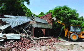 A bulldozer of the Municipal Corporation of Delhi razes the corporations half- constructed toilet-cum-coffee outlet at Bahadur Shah Zafar Marg in New Delhi 