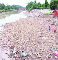 People search for coins on the Gang Canal bed in Haridwar on Wednesday.
