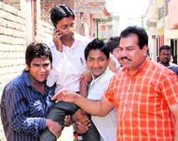 Residents carry SDO Tarun Garg on their shoulders to throw him into the sewer water at Agarsen Colony in Sirsa.