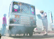 Cops challan an auto-rickshaw for emitting clouds of smoke on International Ozone Day in Ludhiana on Thursday.