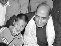 Rajnath Singh, former BJP president, interacts with a child during his visit to the Solar valley relief camp in Choglamsar 