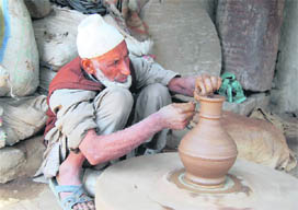 Undeterred by the ongoing turmoil in the Valley, this porter remains busy making clay pots on the outskirts of Srinagar.