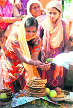 Women perform puja on the banks of a canal on the outskirts of Jammu in connection with Drubri Fast to seek blessings for their children