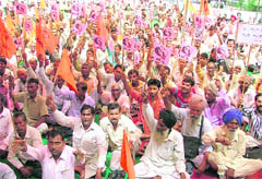 Activists of the BMS hold a protest against price rise in Ludhiana on Friday. 