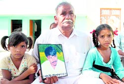Madan Lal shows the photo of his son, who was allegedly killed in a fake encounter.