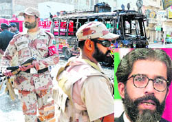 Pakistani paramilitary soldiers patrol the area where a mini passenger bus was torched by angry protesters in Karachi on Friday following the killing of a MQM leader, Dr Imran Farooq (inset), in London. 