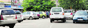 Vehicles parked on a road in front of the electronics market in Sector 18