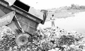 Garbage being dumped along the Sukhna choe at Bishanpura village in Zirakpur on Saturday