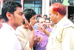 A police official pacifies the protesting students at DAV College in Chandigarh on Saturday