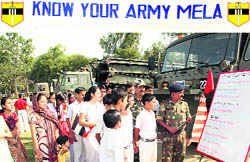 An Army officer educates schoolchildren about the activities of the Army at the mela at the Ratnuchak Military Station near Jammu on Saturday