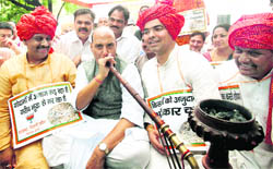 Senior BJP leader Rajnath Singh smokes a hookah as partys Delhi unit chief Vijender Gupta (L) and others look on during a protest against the UPA Government for not distributing foodgrains to the poor and allowing them to rot, in New Delhi