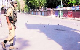 A jawan patrols a street in Srinagar on Sunday.