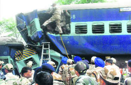 Rescuers inspect a mangled train compartment after a crash in Shivpuri district of MP on Monday.