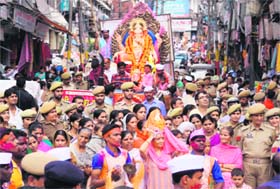 Devotees hold a procession for immersing the idol of Lord Ganesha in the Tawi river in Jammu