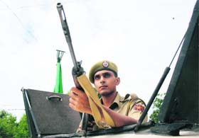 A cop keeps vigil atop a vehicle outside Hotel Ashoka in Jammu on Monday where an all-party delegation from New Delhi will stay