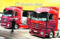 Visitors walk along a display of heavy trucks at the Mercedes-Benz exhibition area during a preview day at the IAA commercial vehicles trade fair in Hanover