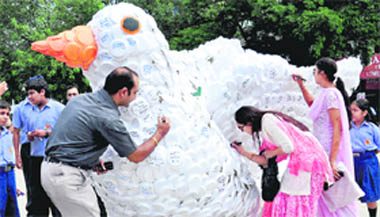 Residents sign on the 8-foot dove, made by students of Dikshant International School, which would be sent to the office of the Chief Minister of Jammu and Kashmir, on the International Peace Day, in Sector 17,Chandigarh, on Tuesday.