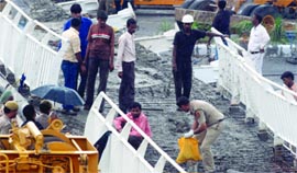 A policeman collects the belongings of the victims at the foot overbridge that collapsed near Jawaharlal Nehru Stadium in New Delhi on Tuesday.