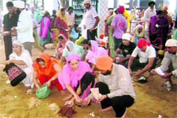 Devotees dig earth to pay obesiance at Guga Marhi at Chhapar village, near Ahmedgarh, on Tuesday