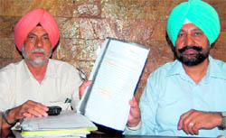 Kharar MLA Balbir Singh Sidhu shows documents pertaining to the allotment of industrial plots, in Mohali on Tuesday