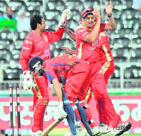 Royal Challengers Bangalores Robin Uthappa celebrates running out Highveld Lions Neil Mckenzie (C) in Johannesburg