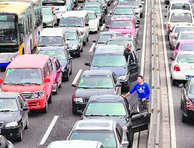 Drivers stuck in traffic step out of their vehicles for a better view on Car Free Day in Beijing on Tuesday.