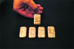 A jeweller displays gold ingots at his shop in Peshawar, Pakistan, on Thursday. Gold held near record highs on Thursday, eyeing a breach of $1,300 an ounce