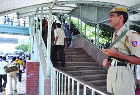 A policeman keeps vigil at a foot overbridge near the ISBT ahead of the Commonwealth Games in New Delhi