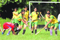 Players vie for the ball during a match of the District School Hockey Tournament in Dehradun 