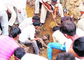 People rescue a labourer from the debris after a wall collapsed in Rohtak