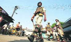 Ueasy calm: Policemen patrol a street in Ayodhya.