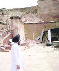 Gurcharan Singh, who is in charge of Kila Mubarak Gurdwara, points to the damaged portion of the historic fort at Bathinda on Thursday. 