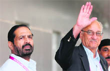 Commonwealth Games Federation chief Mike Fennell (R), accompanied by chairman of the 2010 Commonwealth Games Organising Committee Suresh Kalmadi (L), waves as he arrives at the Indira Gandhi International Airport in New Delhi on Thursday.