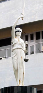 The Statue of Justice holds a balance scale with a single pan at the court complex in Amritsar. 