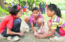 Hockey players play with pebbles on the sidelines during a match in Dehradun on Friday.