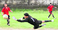 A goalkeeper dives to keep the ball out during a match of the Hishey Memorial Football Tournament in Dehradun 