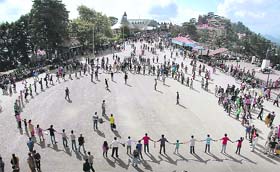 Activists of an NGO play cricket on the Ridge demanding playground for children in Shimla