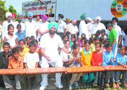 Congress MLA Sukhpal Khaira accompanies schoolchildren on the benches he donated at a government school in Dera Saidan. 