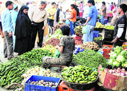 People buy vegetables at Hari Singh High Street market during curfew relaxation in Srinagar on Saturday