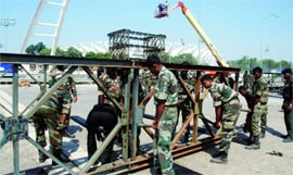 Army personnel build the foot overbridge near Jawaharlal Nehru Stadium in New Delhi on Sunday.