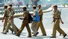 Paramilitary police force along with Delhi police personnel keep a vigil on Games lane at Barapullah Road in New Delhi on Sunday.