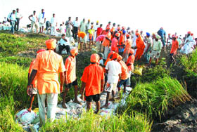 Villagers and followers of Sant Seechewal plug a breach in the dhussi bundh at Gadre Bhode village in Jalandhar.