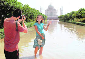 A tourist poses for a photograph in a flooded area near Taj Mahal on Sunday.