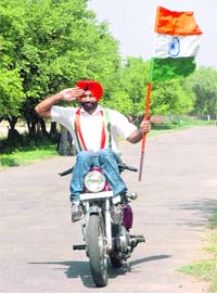Punjab Police Head Constable Nishawar Singh practises on his bike on the DMW road in Patiala