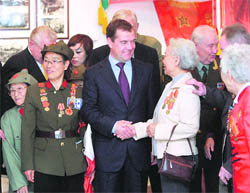 Russian President Dmitry Medvedev speaks to Chinese and Russian WWII veterans after visiting the memorial in Dalian, China, on Sunday.
