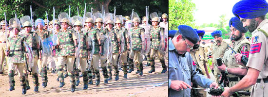 Women police personnel march while an official cleans a weapon ahead of the SSPs inspection in Chandigarh 
