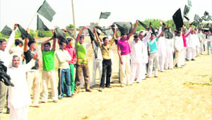 Residents of Danoda wave black flags at the Queens Baton.
