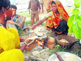 Women workers prepare food on the roadside in Gurgaon.