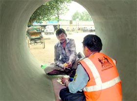 Workers have meals inside a drainage pipe near the Delhi-Gurgaon Expressway in Gurgaon.