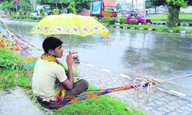 A vendor displays plastic swings near the Mini Secretariat in Karnal on a rainy day.